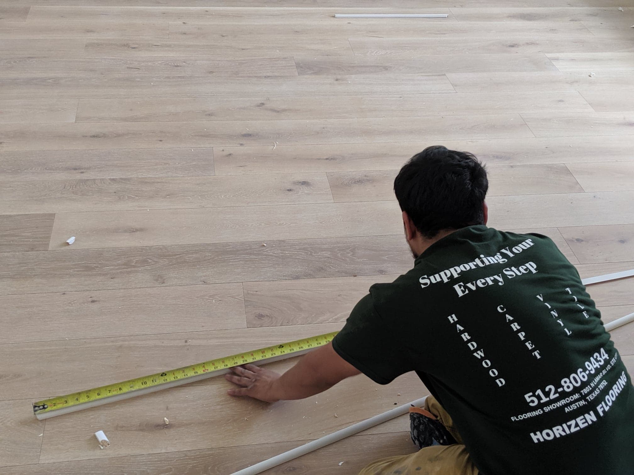 Horizen Flooring craftsman diligently working on the finishing touches to an engineered hardwood flooring installation